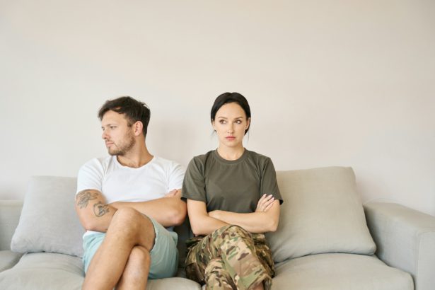 Conflicting couple sitting on sofa in closed poses